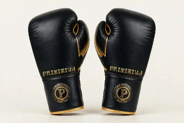 Primitiva Boran BG gants à lacets en noir et doré — vue avant : le logotype Primitiva le long du panneau, l’emblème sur le poignet