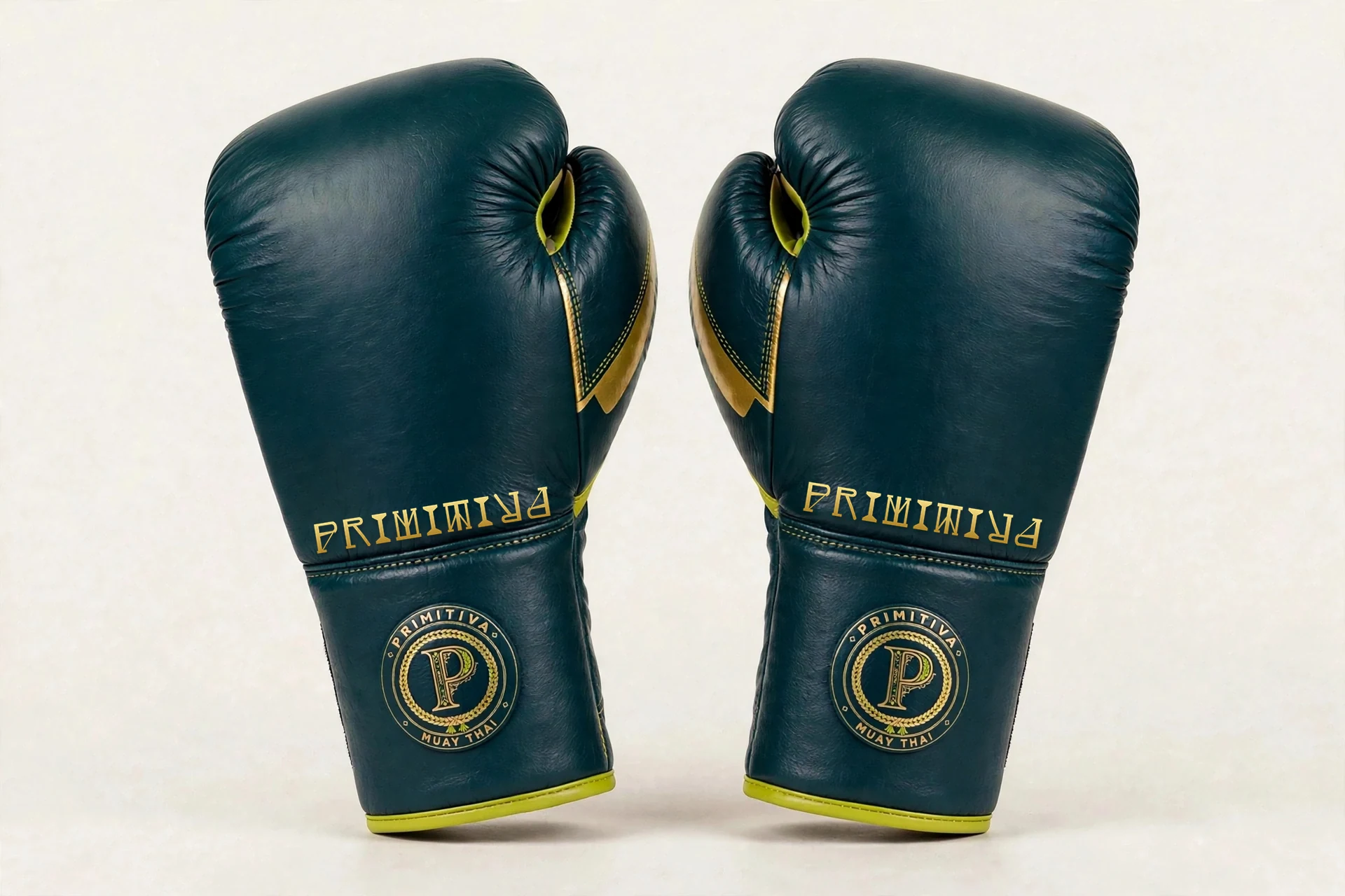 Primitiva Boran lace-up gloves in teal and gold — front view: the Primitiva wordmark along the panel, the emblem on the cuff