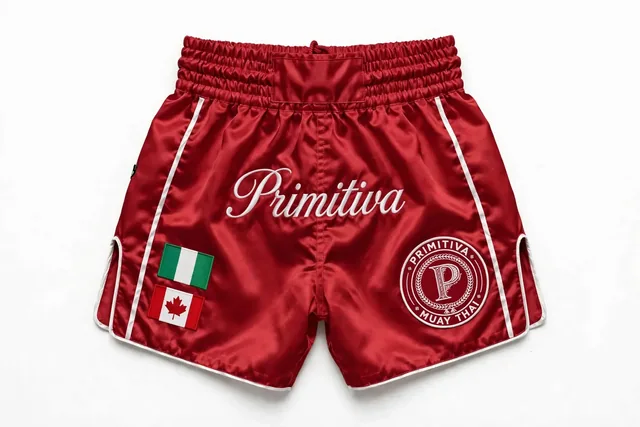 Primitiva short de combat WR — Héritage en rouge et blanc avec les drapeaux du Nigeria et du Canada et inscription sur la ceinture