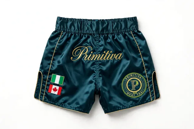 Primitiva short de combat GT — Héritage en sarcelle et doré avec les drapeaux du Nigeria et du Canada et inscription sur la ceinture