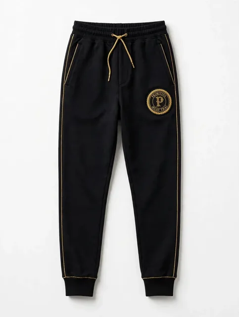 Primitiva pantalon jogger BG en noir et doré avec chevilles à revers et l’emblème sur la cuisse