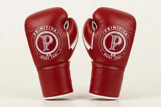 Primitiva Nak Muay WR gants à lacets en rouge et blanc — vue avant : l’emblème sur le poing