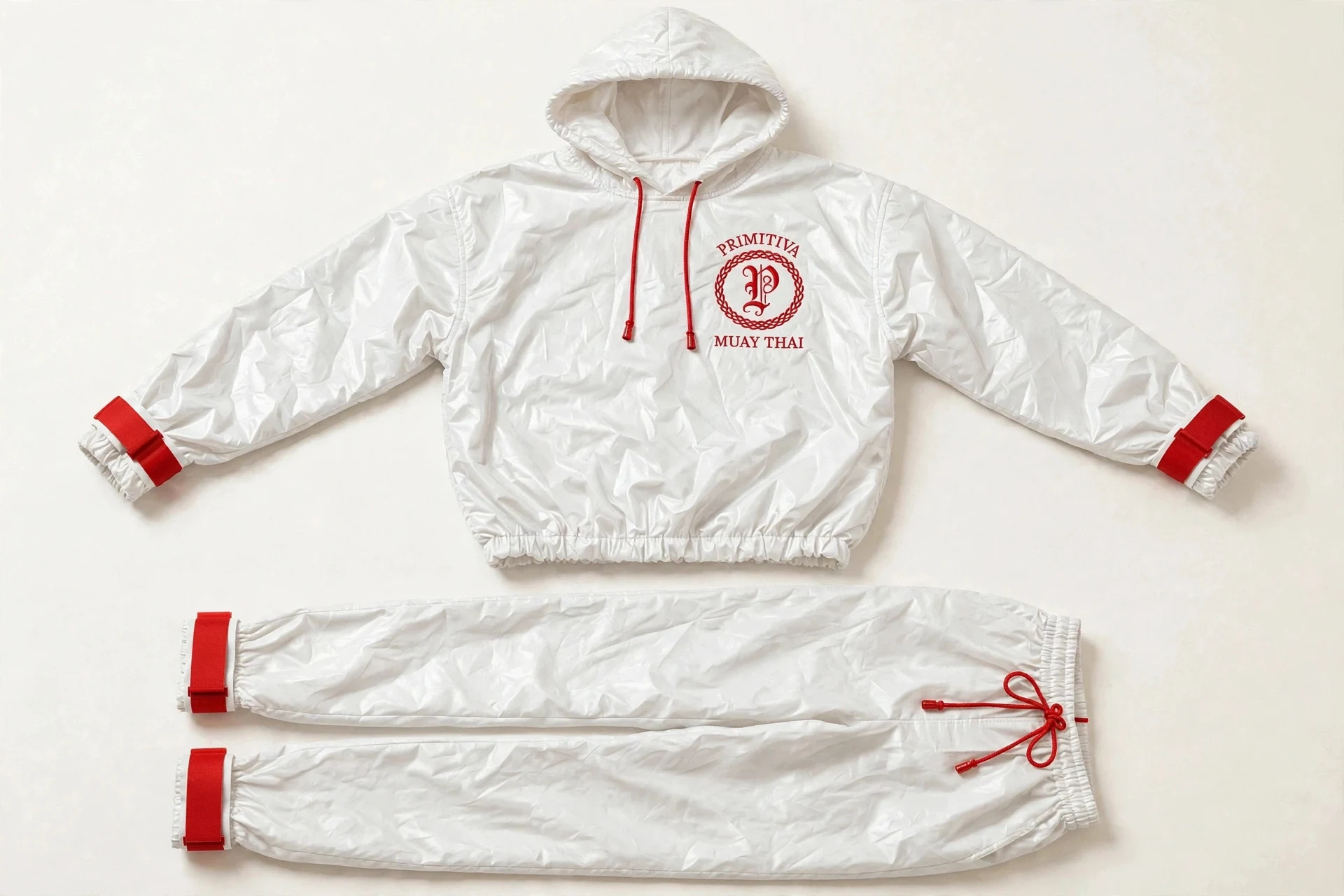 Primitiva Sono WR sauna suit in white and red — hooded pullover and full-length trousers with sealed strap cuffs and the emblem on the chest